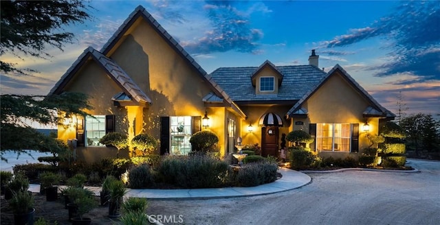 view of front of property with a chimney and stucco siding