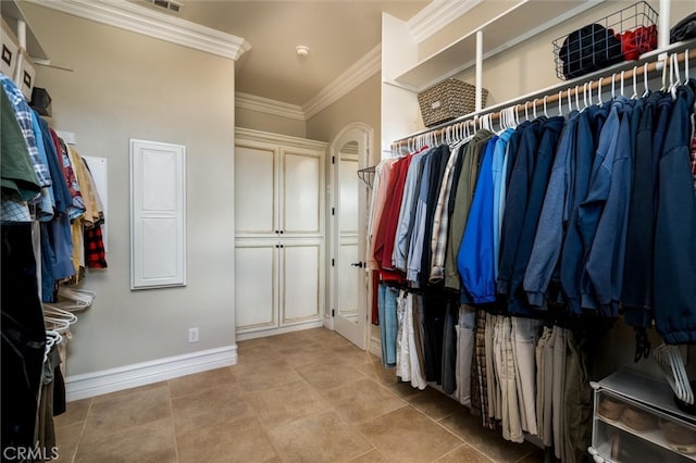 walk in closet with light tile patterned floors