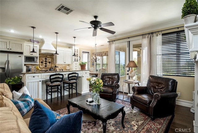 living room featuring ceiling fan with notable chandelier, ornamental molding, and dark hardwood / wood-style floors