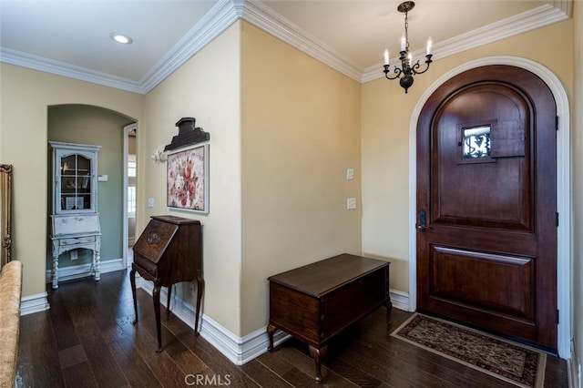 foyer entrance with an inviting chandelier, crown molding, and dark wood-type flooring