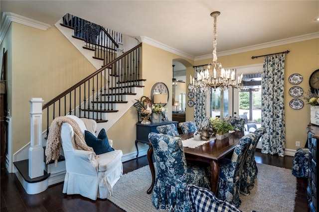 dining space with dark hardwood / wood-style floors, crown molding, and a chandelier