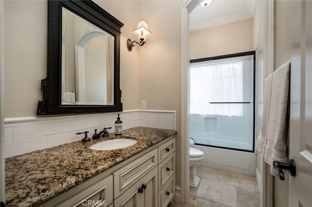 full bathroom featuring vanity, crown molding, combined bath / shower with glass door, toilet, and backsplash