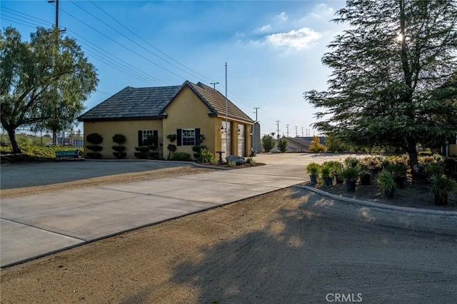 view of home's exterior featuring concrete driveway and stucco siding