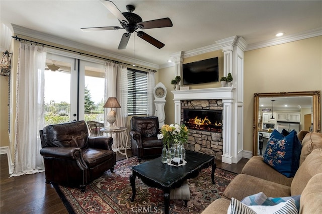 living room with ornamental molding, a fireplace, ceiling fan, and dark hardwood / wood-style floors