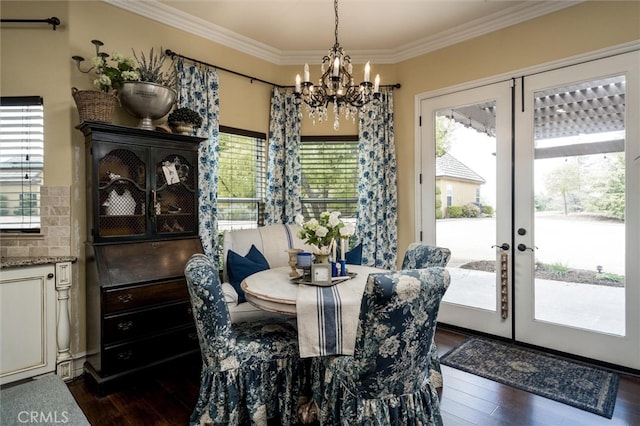 dining area featuring a notable chandelier, crown molding, french doors, and dark hardwood / wood-style flooring