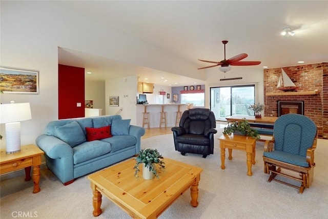 living room with ceiling fan, light colored carpet, and a fireplace