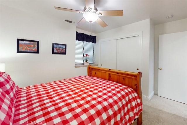 carpeted bedroom featuring ceiling fan and a closet