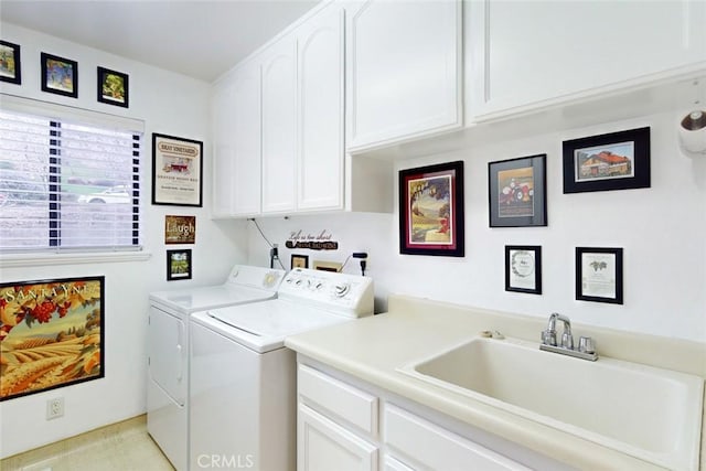 laundry room with cabinets, washing machine and clothes dryer, and sink