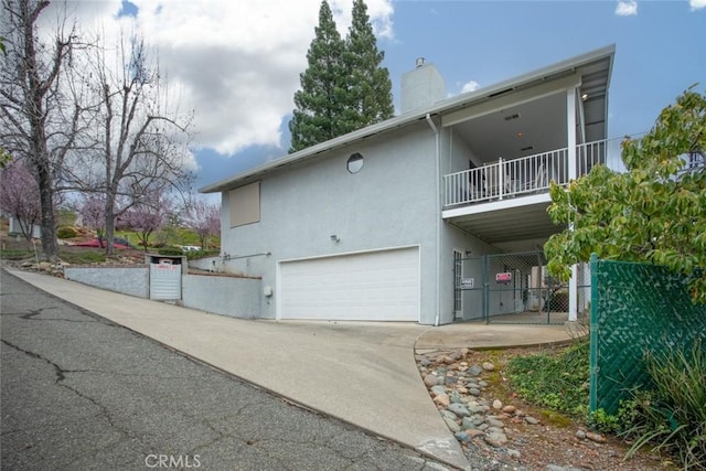 exterior space featuring a garage and a balcony