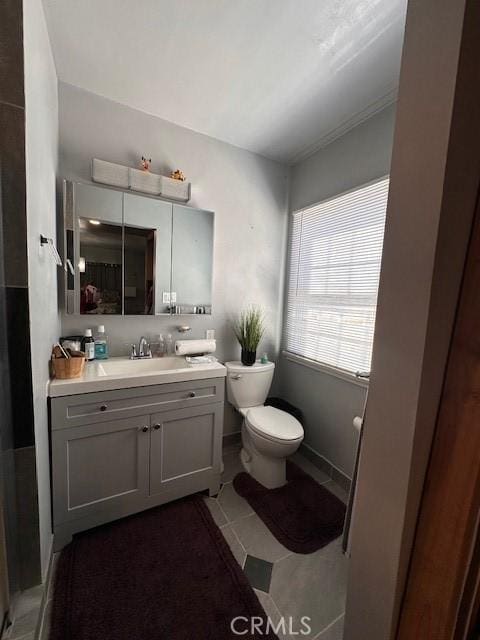 bathroom with tile patterned flooring, vanity, and toilet