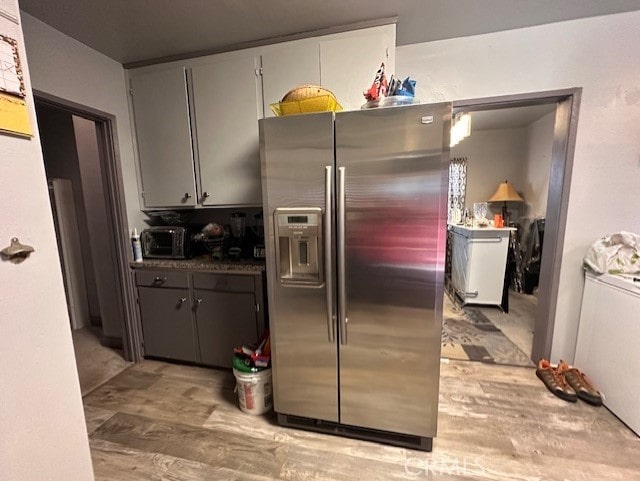 kitchen featuring stainless steel refrigerator with ice dispenser and gray cabinetry