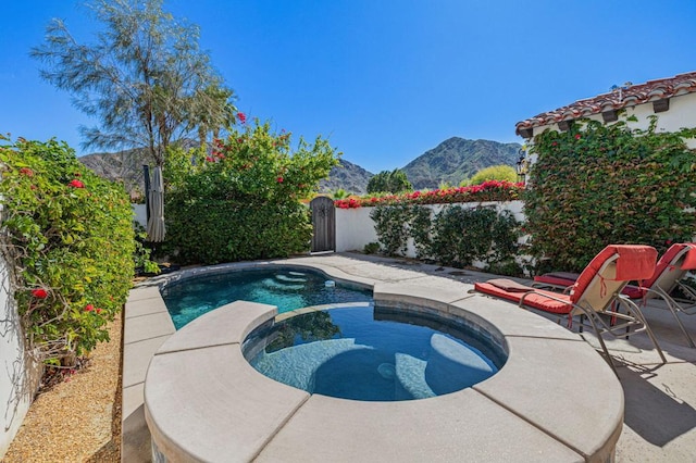 view of swimming pool with a mountain view, an in ground hot tub, and a patio area