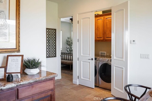 clothes washing area with ceiling fan, cabinets, and separate washer and dryer