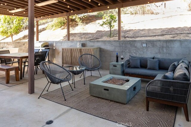 view of patio with grilling area and an outdoor living space with a fire pit