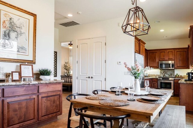 dining room with ceiling fan with notable chandelier