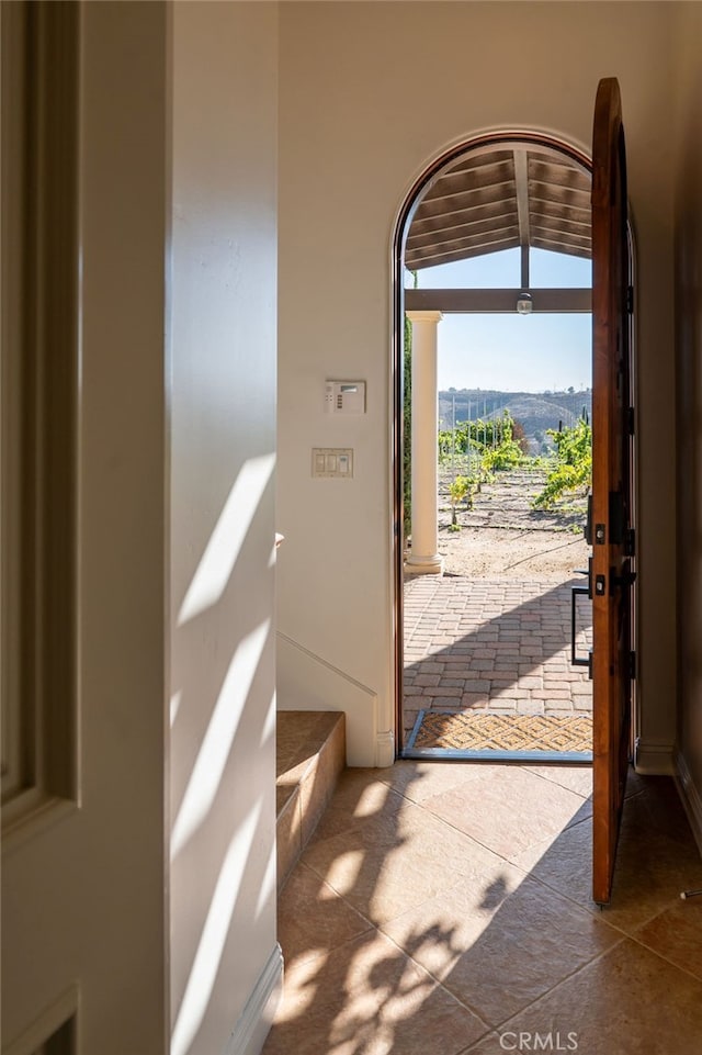 doorway with a mountain view and vaulted ceiling