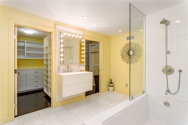 bathroom with tiled shower / bath, vanity, and tile patterned flooring