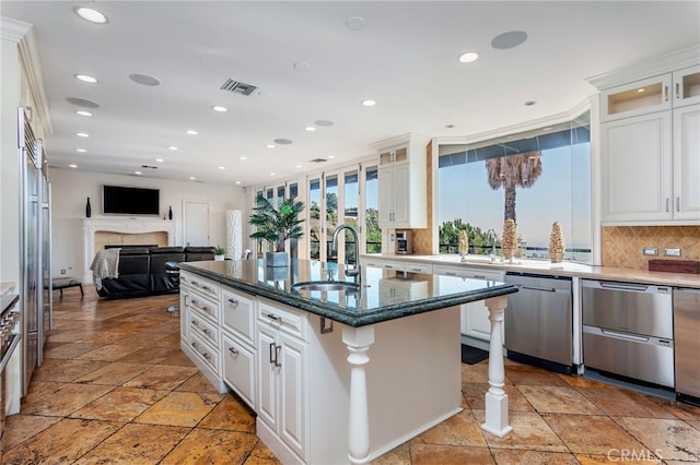 kitchen with white cabinets, dishwasher, a center island with sink, and tasteful backsplash