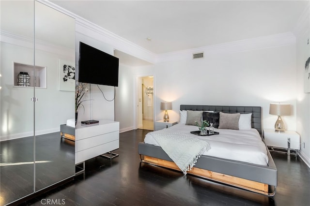 bedroom featuring a closet, dark hardwood / wood-style floors, and ornamental molding