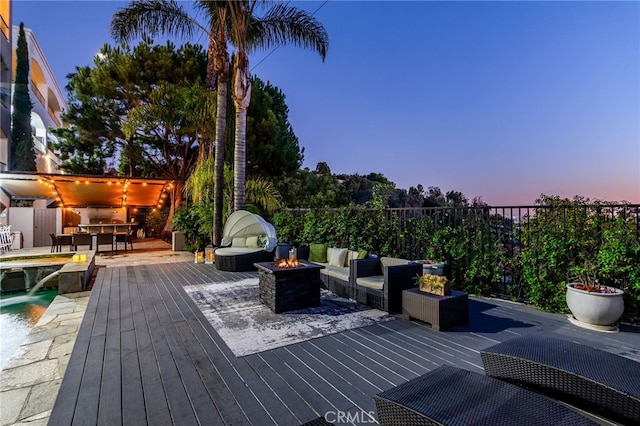 deck at dusk featuring a fire pit