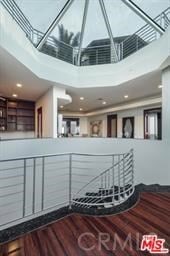 stairway with a high ceiling and wood-type flooring