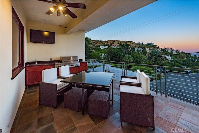 view of patio / terrace featuring ceiling fan, sink, grilling area, a balcony, and an outdoor kitchen