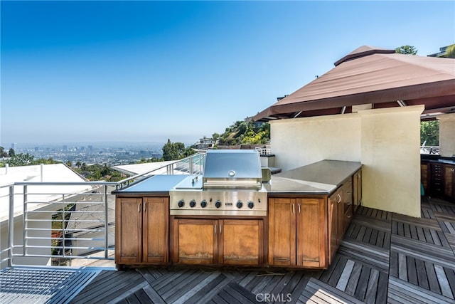 wooden terrace with area for grilling and an outdoor kitchen