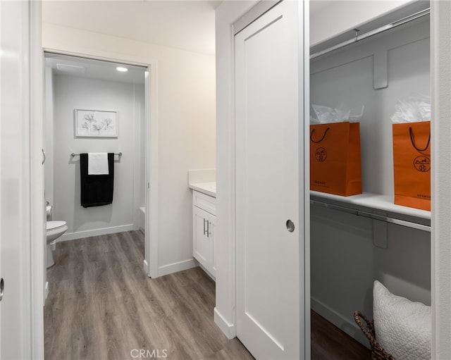 bathroom with vanity, toilet, hardwood / wood-style flooring, and a bathing tub