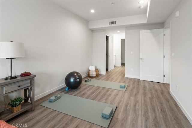 workout area with light hardwood / wood-style floors