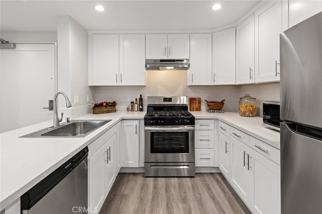 kitchen featuring appliances with stainless steel finishes, light hardwood / wood-style flooring, white cabinetry, and sink