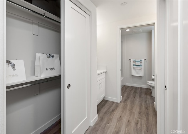 bathroom featuring vanity, toilet, hardwood / wood-style flooring, and a bath