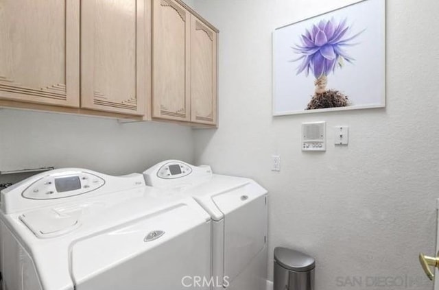 laundry room featuring cabinets and washing machine and dryer