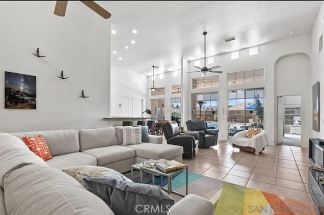 tiled living room with a towering ceiling and ceiling fan