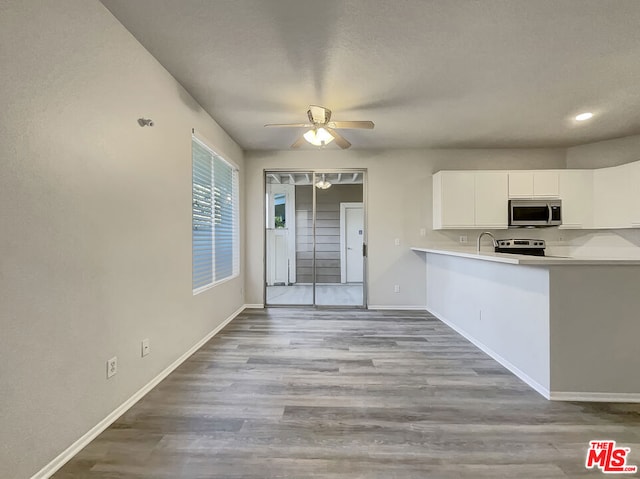 kitchen featuring light hardwood / wood-style flooring, white cabinets, ceiling fan, and appliances with stainless steel finishes