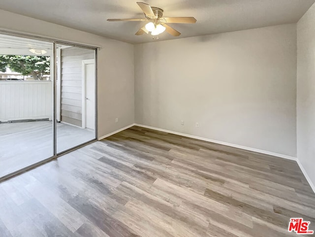 unfurnished bedroom with ceiling fan, a closet, and hardwood / wood-style flooring