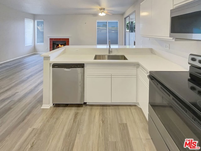 kitchen with sink, white cabinetry, kitchen peninsula, stainless steel appliances, and ceiling fan