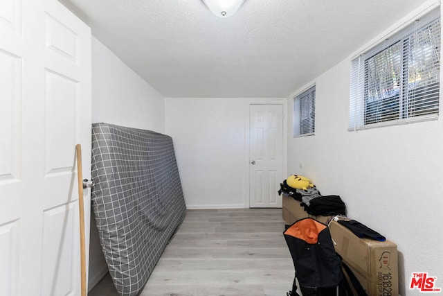 miscellaneous room featuring a textured ceiling and light wood-type flooring