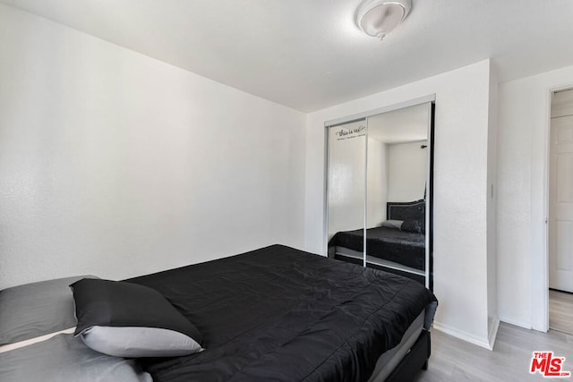 bedroom with a closet and light hardwood / wood-style floors