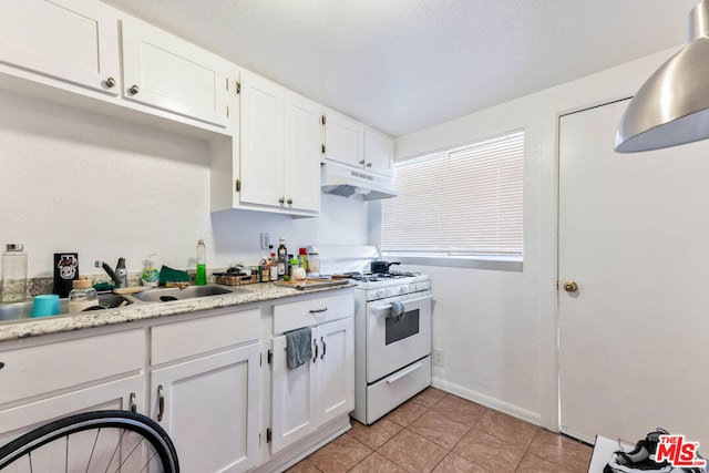 kitchen featuring light tile patterned floors, white cabinets, sink, and white range with gas cooktop