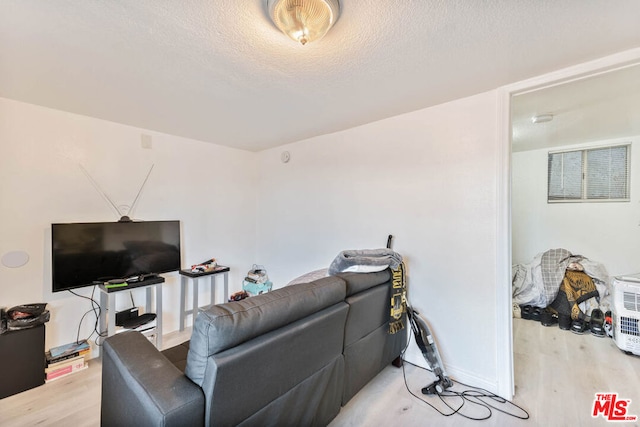 living room featuring a textured ceiling and light wood-type flooring