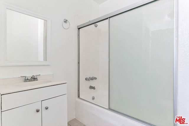 bathroom featuring enclosed tub / shower combo and vanity