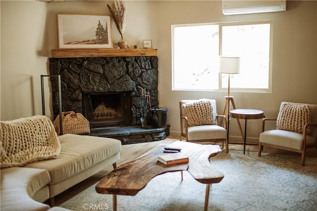 living area featuring a stone fireplace and a wall mounted AC