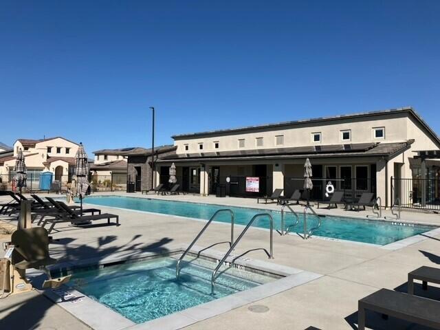 view of swimming pool featuring a patio and a hot tub