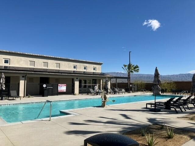 view of swimming pool featuring a patio and a mountain view