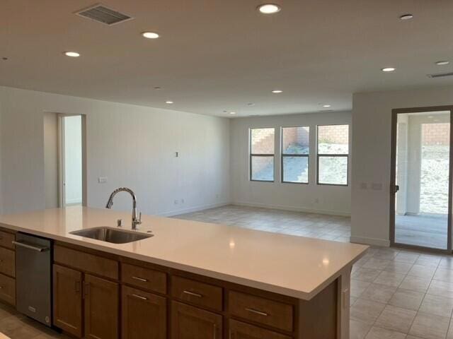 kitchen featuring a center island with sink, sink, and stainless steel dishwasher