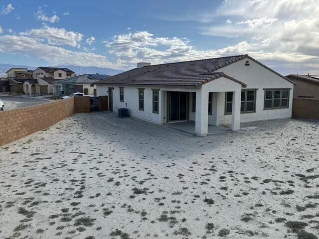 rear view of property featuring central AC unit and a patio