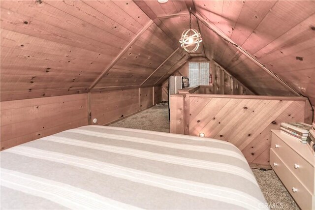 unfurnished bedroom with lofted ceiling, wood walls, light colored carpet, and wooden ceiling