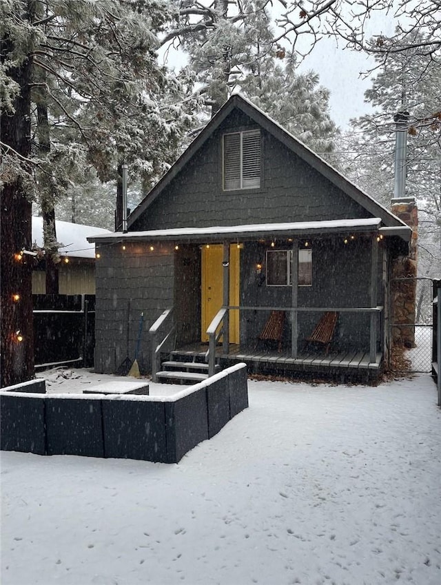 view of snow covered back of property