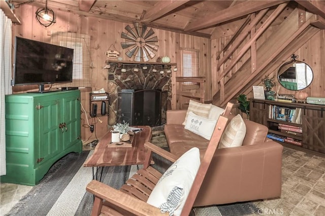 living room with wood ceiling, a fireplace, beam ceiling, and wood walls