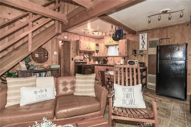 living room featuring track lighting, wooden walls, sink, and beam ceiling